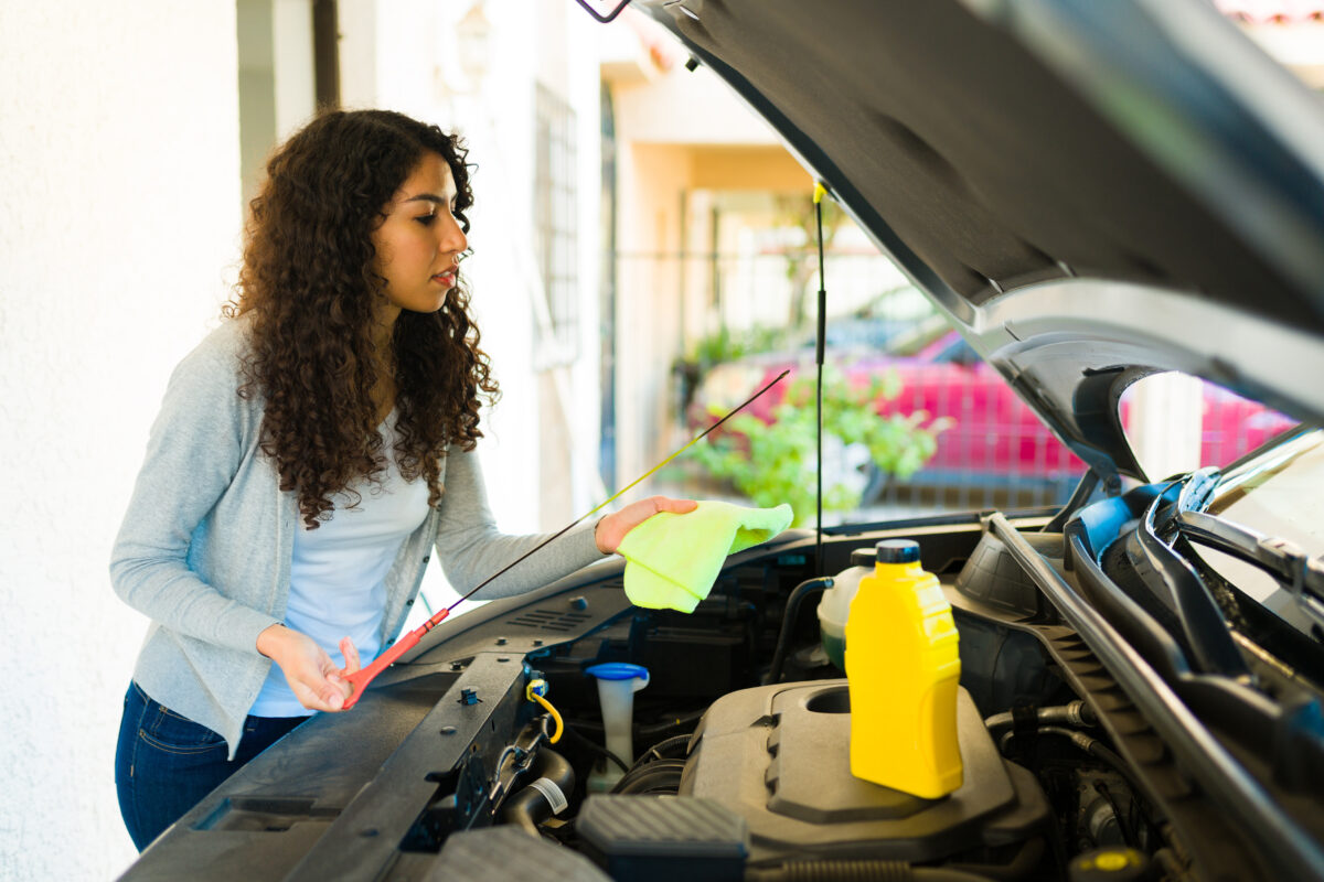 woman checks car fluids